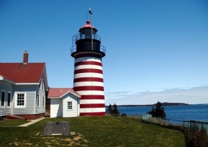 red & white horizontally stripped lighthouse w/ blue sea & sky as background