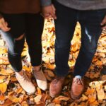 Couple's feet in fall leaves
