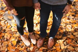 Couple's feet in fall leaves