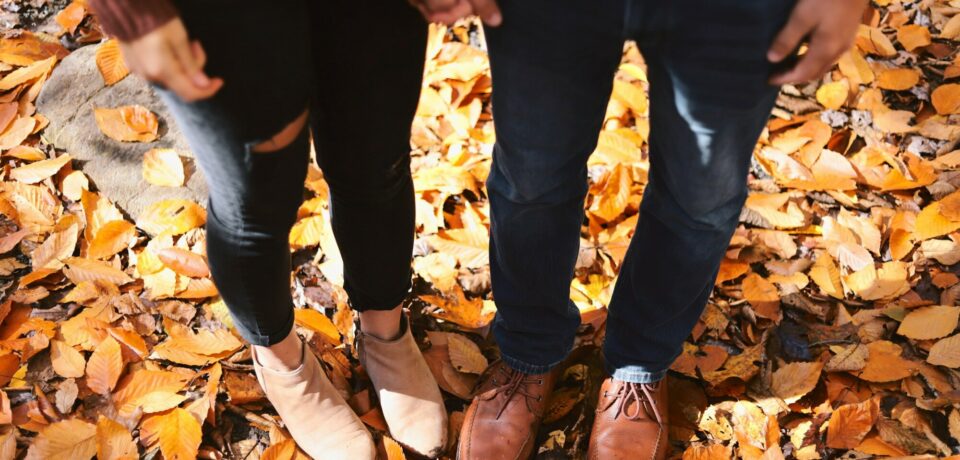 Couple's feet in fall leaves