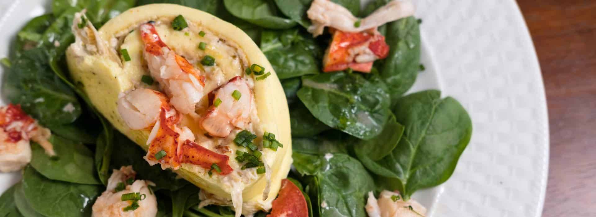 Close up view of seafood and green salad dish on white plate
